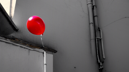 A red balloon tied to a drainpipe in the gutter, with a shadowy figure lurking in the background.